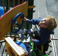 Joseph playing on a play panel at Shane's Inspiration at Griffith Park